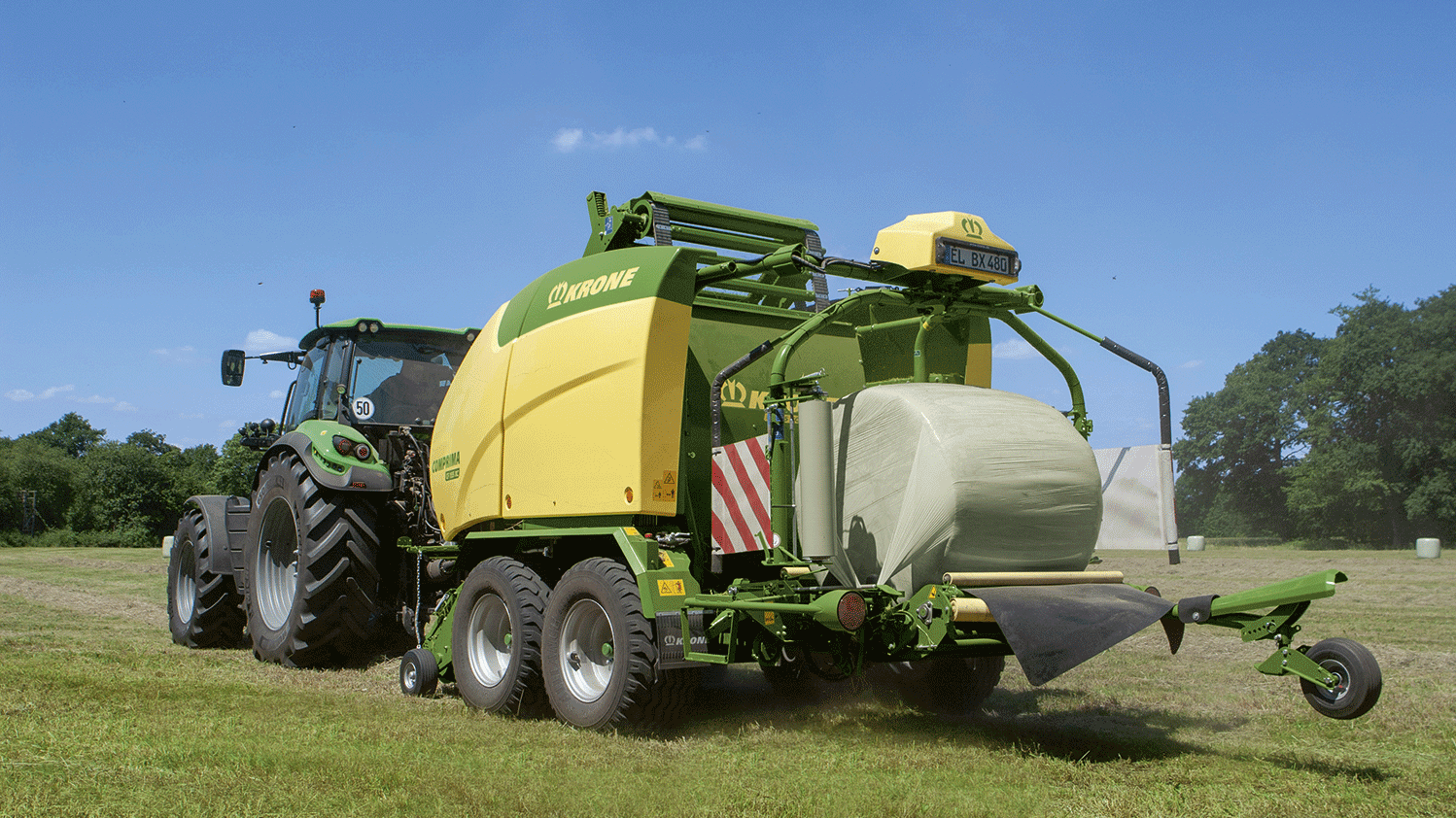 Round Baler - KRONE Comprima rear view on grass field